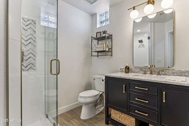 bathroom with vanity, wood-type flooring, a shower with door, and toilet