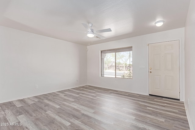 spare room featuring baseboards, a ceiling fan, and wood finished floors