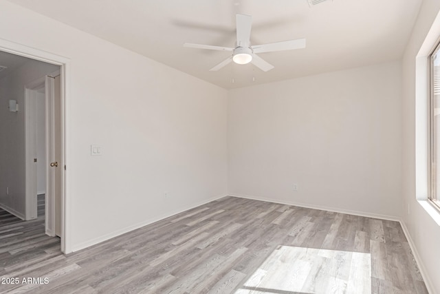 unfurnished room featuring a ceiling fan, light wood-style flooring, and a wealth of natural light