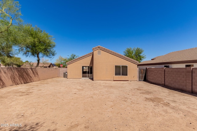 back of house with a fenced backyard and stucco siding
