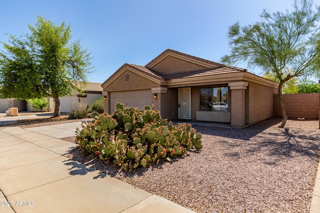 ranch-style house featuring fence, stucco siding, a tiled roof, an attached garage, and driveway