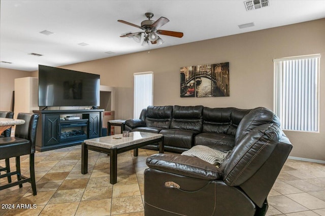 living area featuring visible vents, ceiling fan, and baseboards