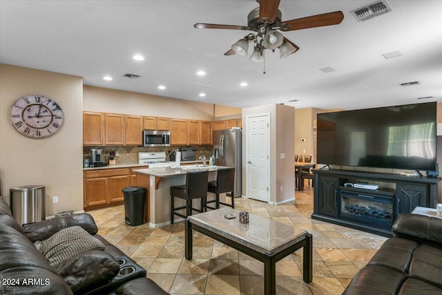 living room with ceiling fan, visible vents, and recessed lighting