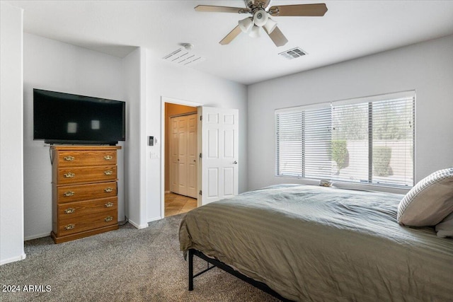 bedroom featuring baseboards, visible vents, a ceiling fan, and light colored carpet