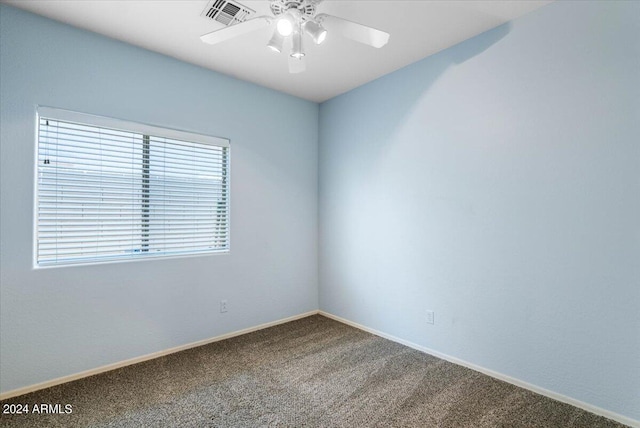 carpeted spare room with ceiling fan, visible vents, and baseboards