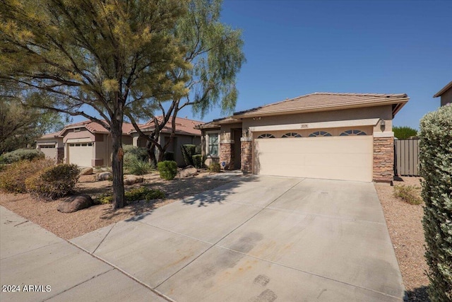 view of front facade featuring a garage, stone siding, concrete driveway, and stucco siding