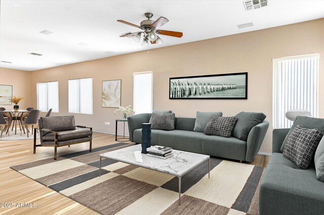 living area featuring a ceiling fan, visible vents, and light wood finished floors