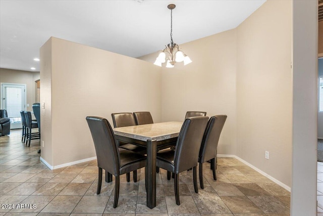 dining area with a chandelier and baseboards