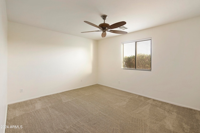 spare room featuring light colored carpet and ceiling fan