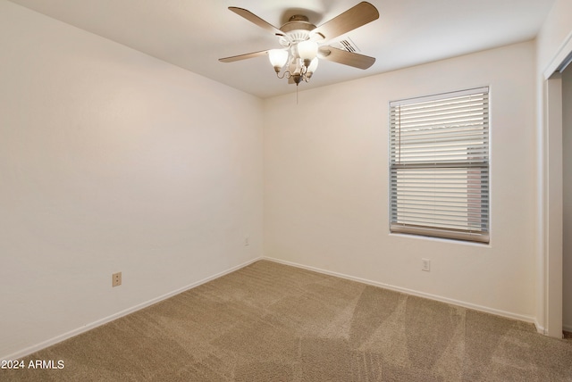 carpeted spare room with ceiling fan