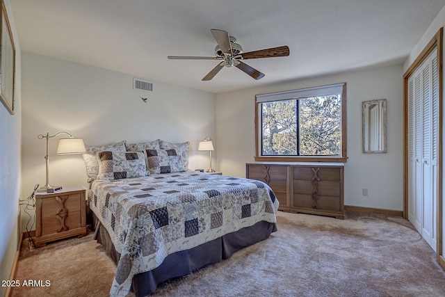 carpeted bedroom with ceiling fan and a closet