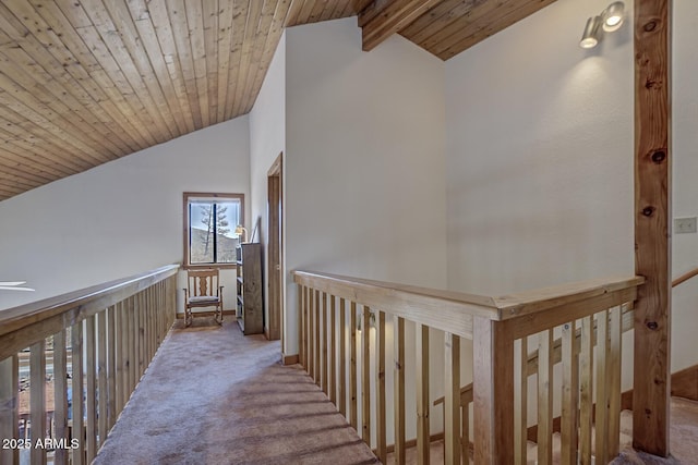 hallway featuring light carpet, lofted ceiling with beams, and wooden ceiling