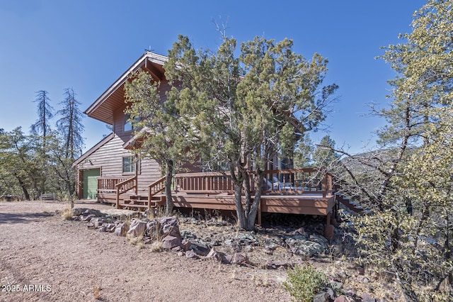 back of house with a wooden deck and a garage