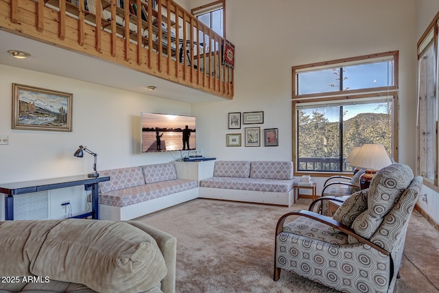 carpeted living room with plenty of natural light and a towering ceiling