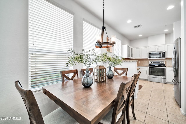 dining area featuring light tile patterned flooring and a chandelier