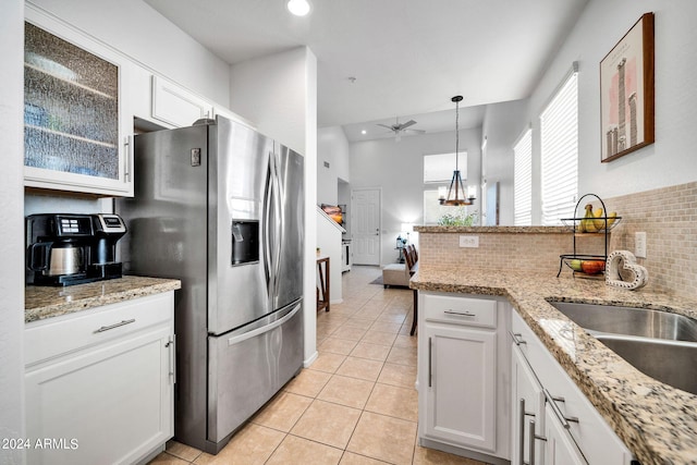 kitchen featuring white cabinetry, hanging light fixtures, light tile patterned floors, and stainless steel fridge