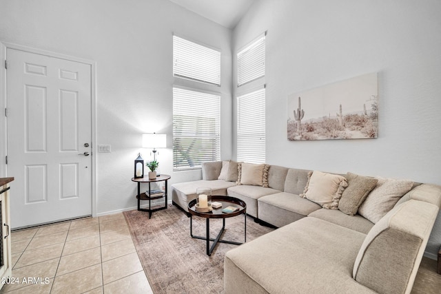 living room featuring a towering ceiling and light tile patterned flooring