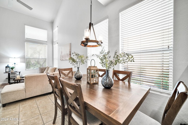 dining room featuring light tile patterned floors and a towering ceiling