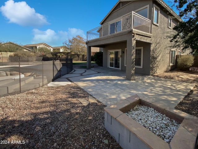 back of property with a balcony and a patio