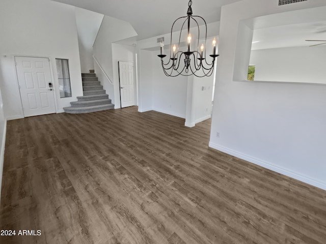 unfurnished dining area with dark hardwood / wood-style floors and ceiling fan with notable chandelier