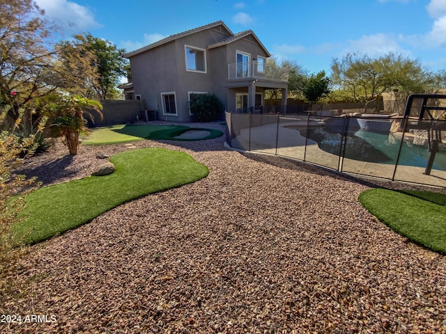 exterior space with a balcony and a fenced in pool