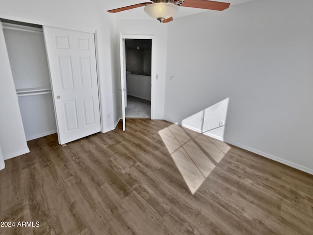 unfurnished bedroom featuring ceiling fan, dark hardwood / wood-style floors, and a closet