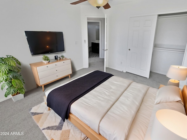 carpeted bedroom featuring ceiling fan and a closet