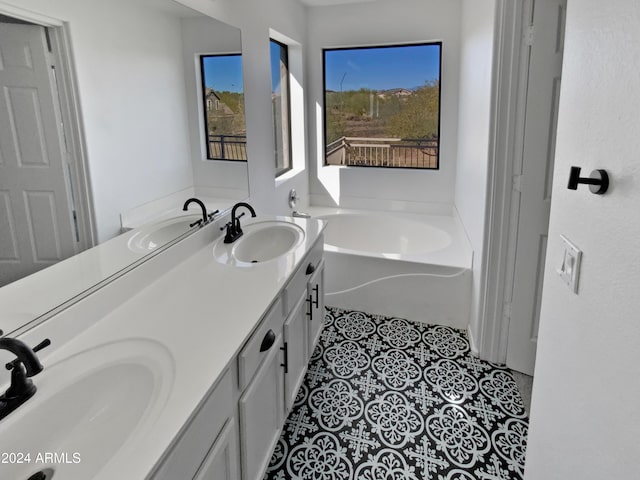 bathroom featuring tile patterned flooring, vanity, and a washtub