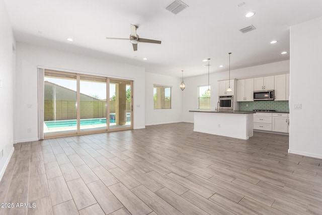 20499 W Alsap Rd, Buckeye, AZ 85396 - unfurnished living room with ceiling fan, recessed lighting, light wood finished floors, and baseboards