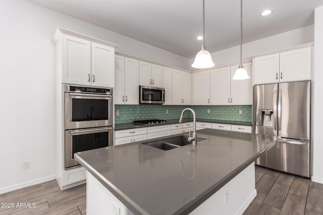 20499 W Alsap Rd, Buckeye, AZ 85396 - kitchen with appliances with stainless steel finishes, a sink, dark countertops, wood finished floors, and recessed lighting