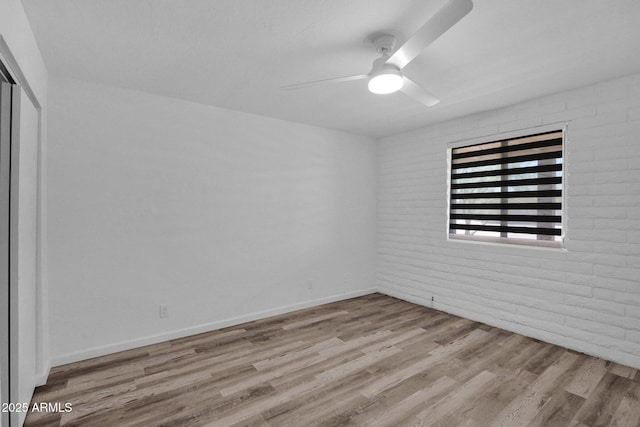 29835 N 56th St N, Cave Creek, AZ 85331 - spare room featuring wood finished floors, ceiling fan, brick wall, and baseboards