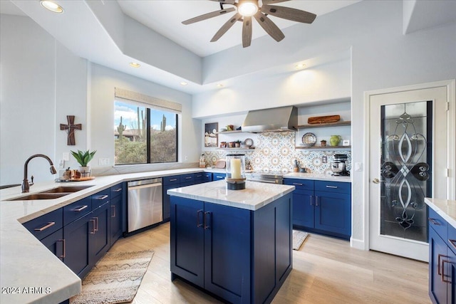 kitchen featuring wall chimney exhaust hood, dishwasher, a center island, ceiling fan, and light hardwood / wood-style flooring