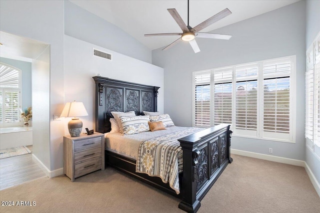 carpeted bedroom with connected bathroom, ceiling fan, and high vaulted ceiling