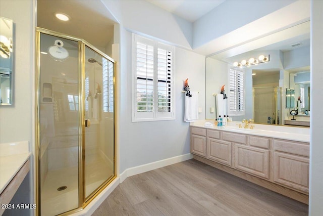 bathroom with vanity, hardwood / wood-style floors, and a shower with door