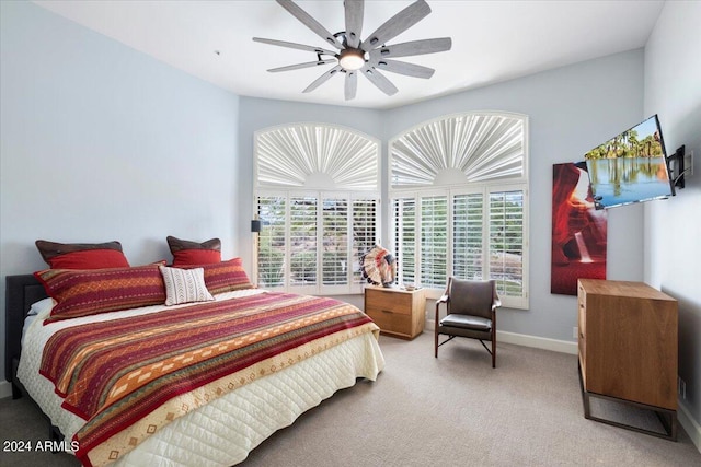 carpeted bedroom with ceiling fan and multiple windows