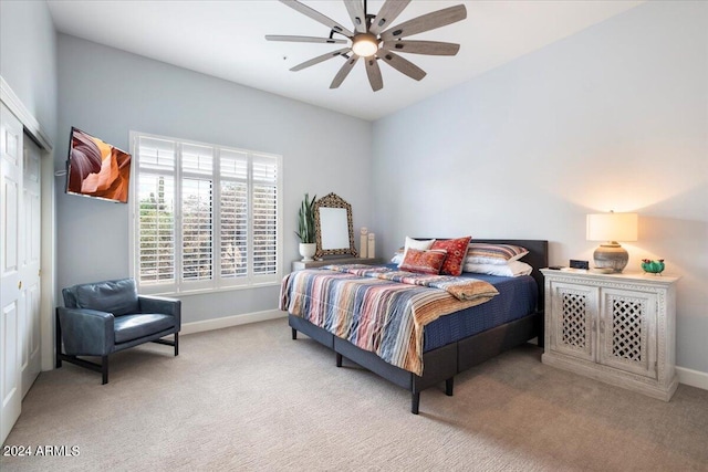 carpeted bedroom with ceiling fan and a closet