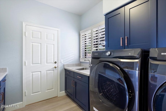 washroom with light hardwood / wood-style floors, sink, independent washer and dryer, and cabinets