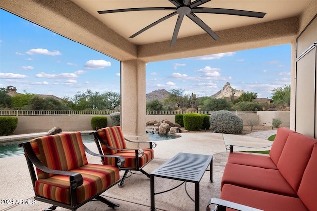 view of patio / terrace featuring a fenced in pool, outdoor lounge area, ceiling fan, and a mountain view