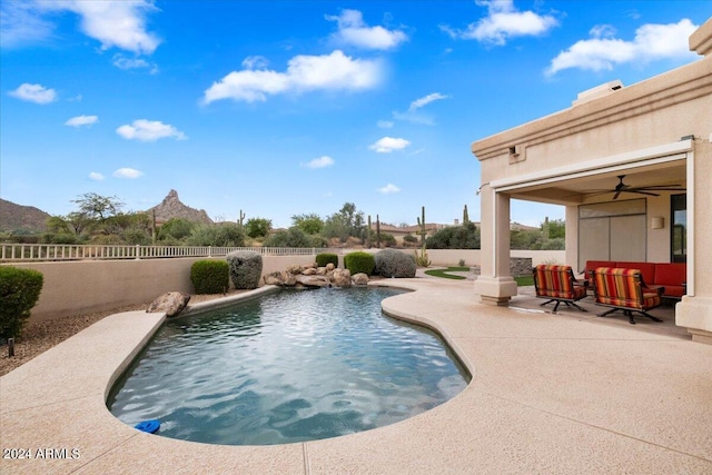 view of pool with ceiling fan, a mountain view, and a patio