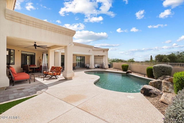 view of swimming pool featuring ceiling fan and a patio area