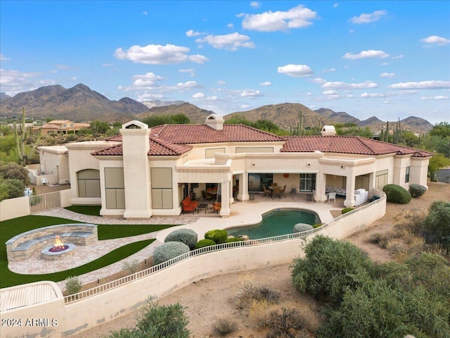 rear view of house featuring a patio, an outdoor fire pit, and a mountain view