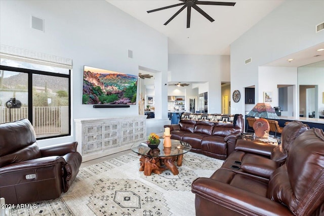 living room with ceiling fan and high vaulted ceiling