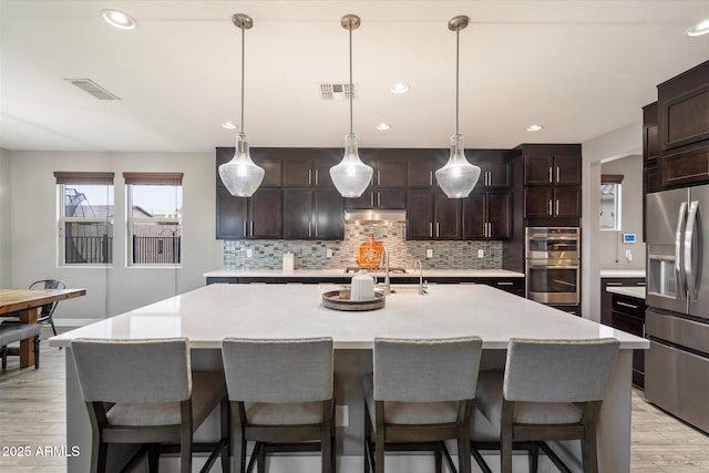 10702 E Sheffield Dr, Mesa, AZ 85212 - kitchen with tasteful backsplash, stainless steel appliances, a large island, and hanging light fixtures