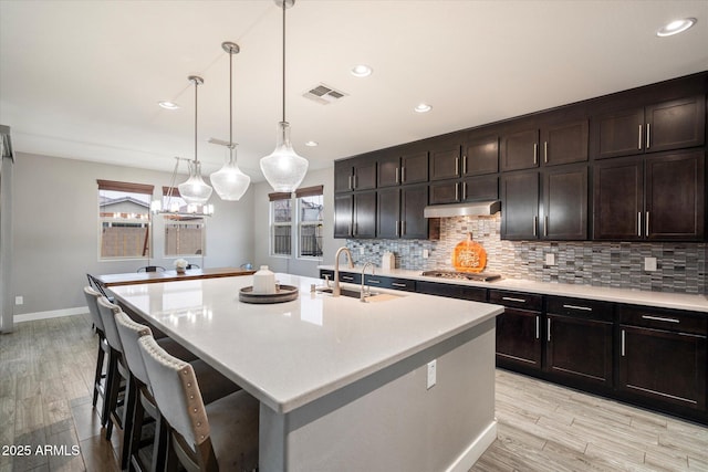 10702 E Sheffield Dr, Mesa, AZ 85212 - kitchen featuring sink, dark brown cabinets, and an island with sink