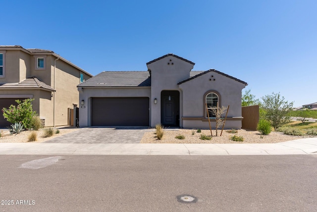 5954 E Cat Balue Dr, Phoenix, AZ 85054 - mediterranean / spanish-style house featuring stucco siding, driveway, an attached garage, and a tiled roof