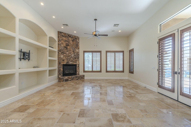 unfurnished living room featuring a stone fireplace, visible vents, baseboards, built in features, and french doors