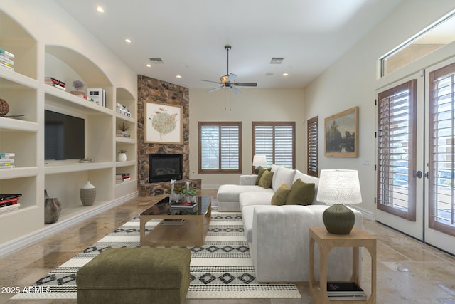 living room with a healthy amount of sunlight, visible vents, built in features, and french doors