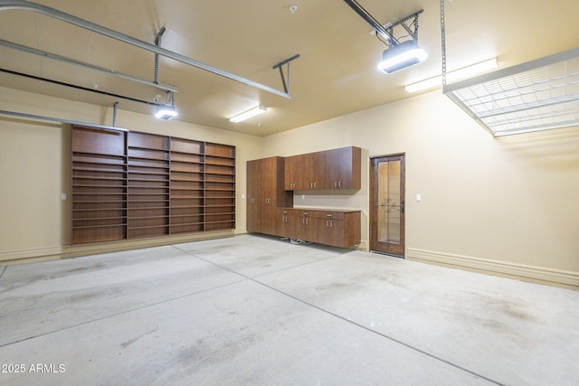 garage with baseboards and a garage door opener