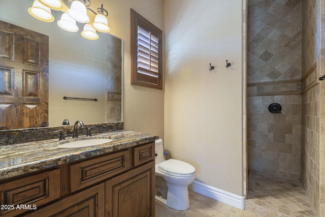 full bathroom with toilet, a notable chandelier, vanity, baseboards, and tiled shower