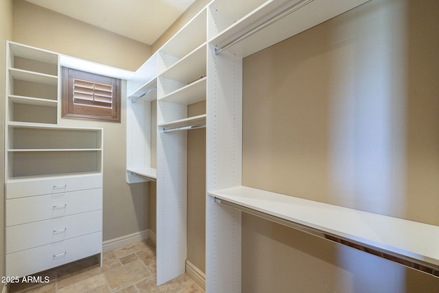 walk in closet with stone finish flooring